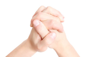 clasped hands praying on white background