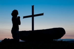 Woman praying at cross