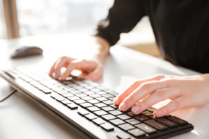 woman's hands on computer keyboard