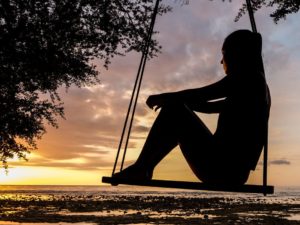 woman on swing, thinking and considering an adoption plan