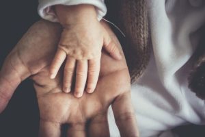 Baby hand in parent hand: represents pro-life values