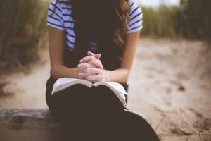 woman reading Bible outside in act of renewal